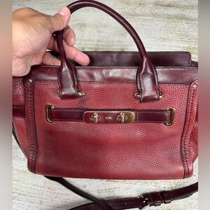 This is a Coach Swagger Carryall bag, crafted from pebbled leather in oxiblood